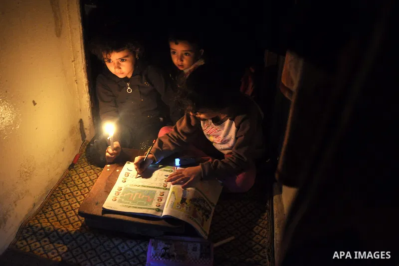 Palestinian children study on candles light during a power cut in Al-Shatea' refugee camp in Gaza City on November 8, 2013. Gaza's lone power plant shut its generators on Friday due to a fuel shortage, a move that will l...