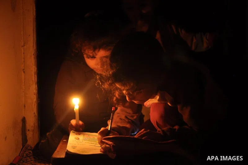 Palestinian children study on candles light during a power cut in in Al-Shatea' refugee camp in Gaza City on November 8, 2013. Gaza's lone power plant shut its generators on Friday due to a fuel shortage, a move that wil...