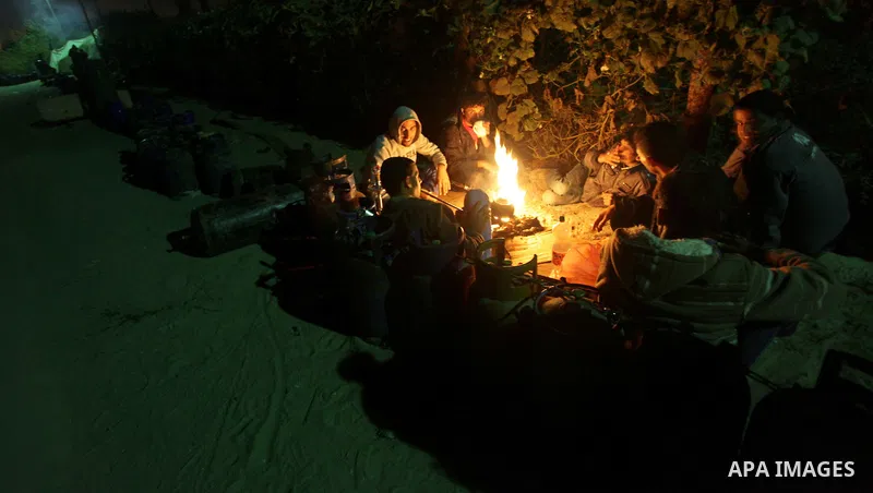 Palestinian men wait for the night to fill cooking gas canisters outside a filling station at Deir al-Balah in central Gaza Strip November 12, 2013. Palestinian officials said Israel allows limited quantity of cooking ga...