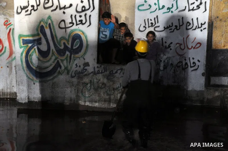 A Palestinian worker wroks in a flooded street with sewage in al-Sabra neighborhood, in Gaza City on November 13, 2013. The main pump of sewage water which serves thousands of citizens in a densely populated area was sto...