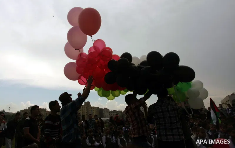Palestinians hold balloons in the colour of the national flag to mark the 25th anniversary of the Palestinian Independence Day, in Gaza city, on Nov. 17, 2013. Palestinians have marked Nov. 15 as their Independence Day s...