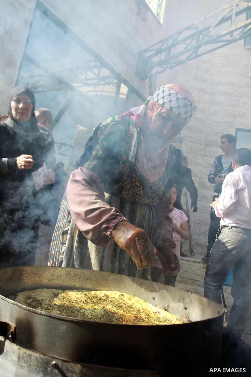 A Palestinian woman prepares pastry of olive oil during the opening of olive oil festival, in the West Bank town of Salfit, southern Nablus, November 17, 2013. Photo by Nedal Eshtayah