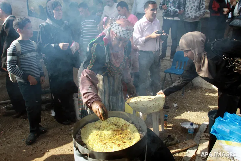 A Palestinian woman prepares pastry of olive oil during the opening of olive oil festival, in the West Bank town of Salfit, southern Nablus, November 17, 2013. Photo by Nedal Eshtayah