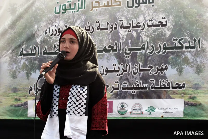 A Palestinian woman speaks during the opening of olive oil festival, in the West Bank town of Salfit, southern Nablus, November 17, 2013. Photo by Nedal Eshtayah
