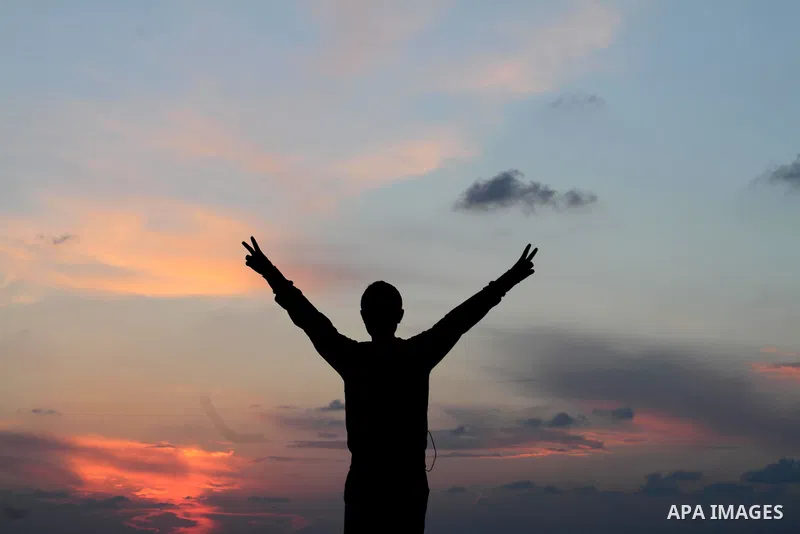 A Palestinian youth flashes the victory sign at the beach of Gaza City during the sunset, in Gaza, November 17, 2013. Photo by Mohammed Asad