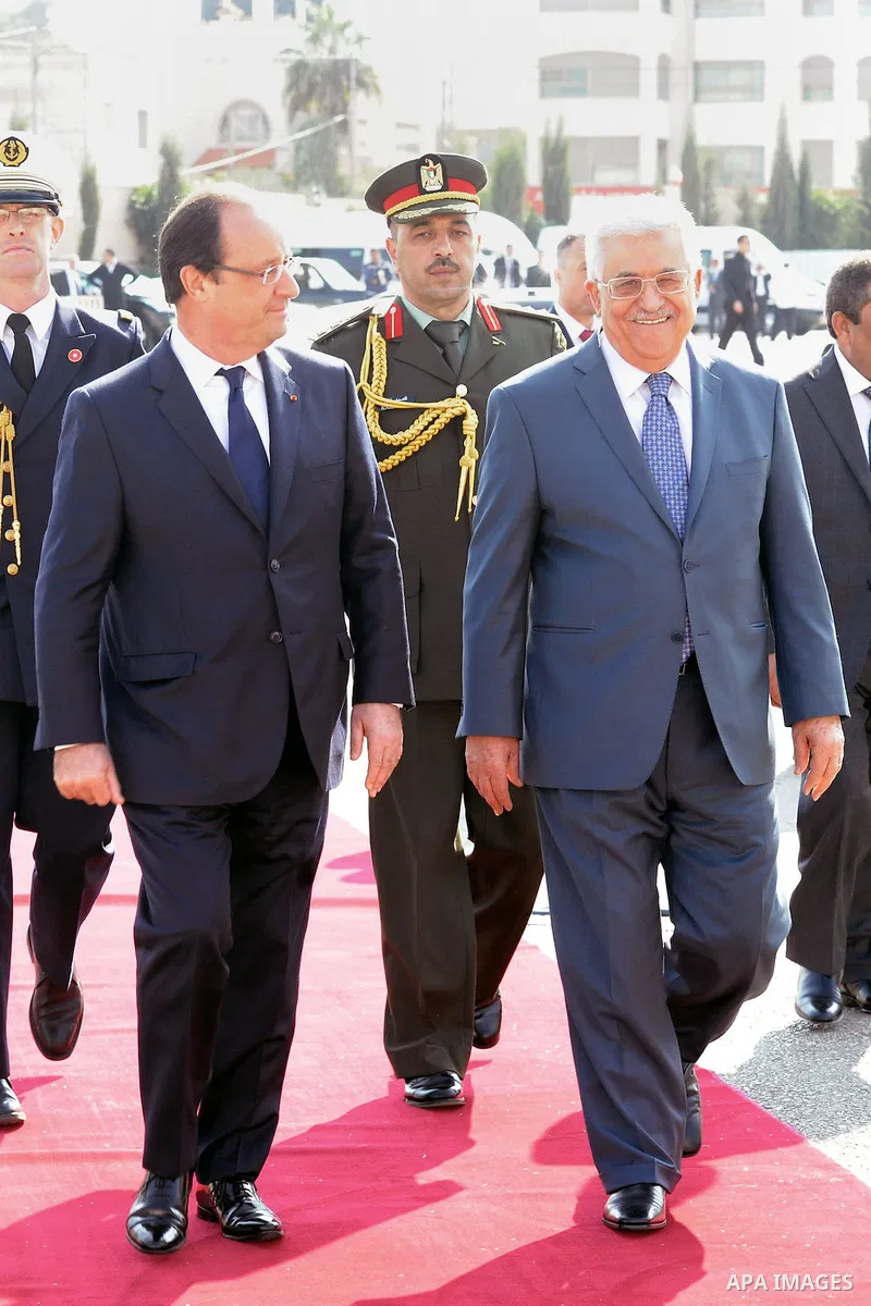 Palestinian President Mahmoud Abbas, and French President Francois Hollande walk past an honor guard during a welcoming ceremony in the West Bank city of Ramallah, on November 18, 2013. Hollande is expected to meet with...