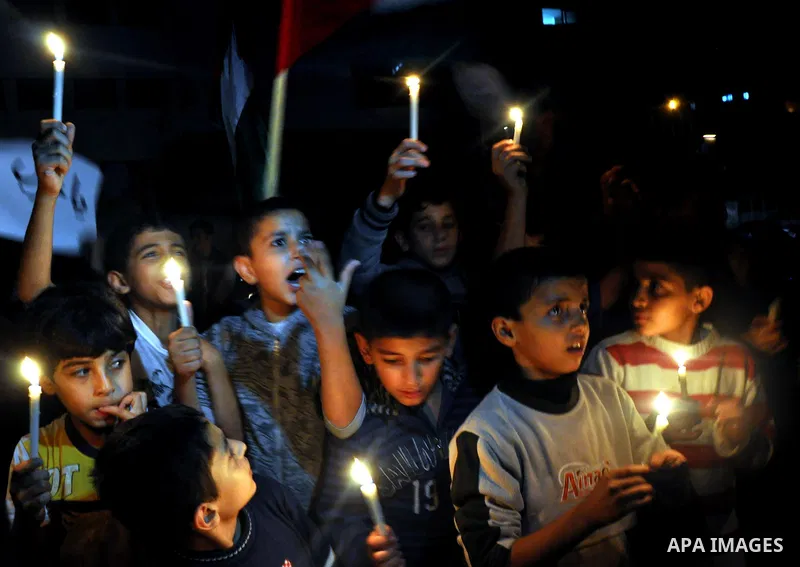 Palestinian children light candles during a rally marking ''Universal Children's Day'' calling for end the blockade on Gaza Strip, in Gaza City on November 20, 2013. Photo by Mohammed Talatene