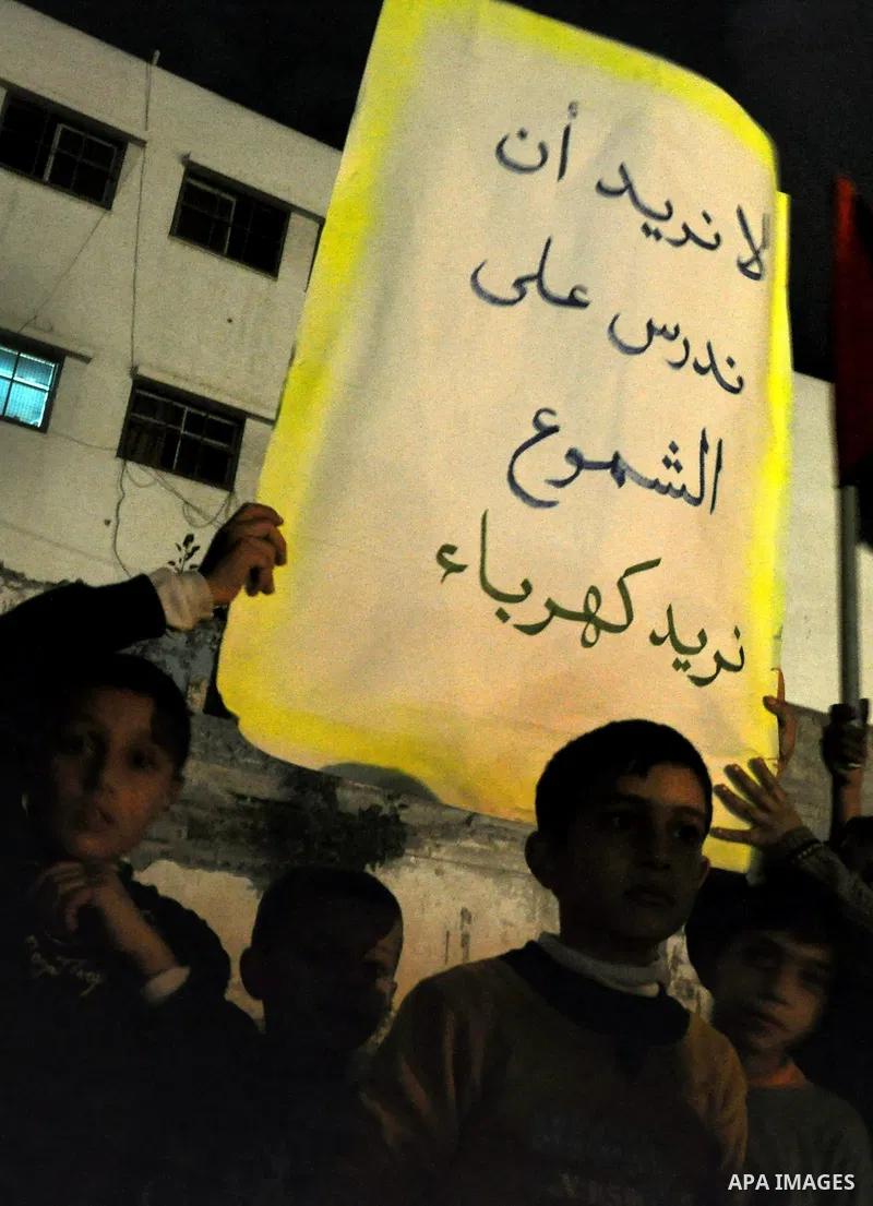 Palestinian children light candles during a rally marking ''Universal Children's Day'' calling for end the blockade on Gaza Strip, in Gaza City on November 20, 2013. Photo by Mohammed Talatene