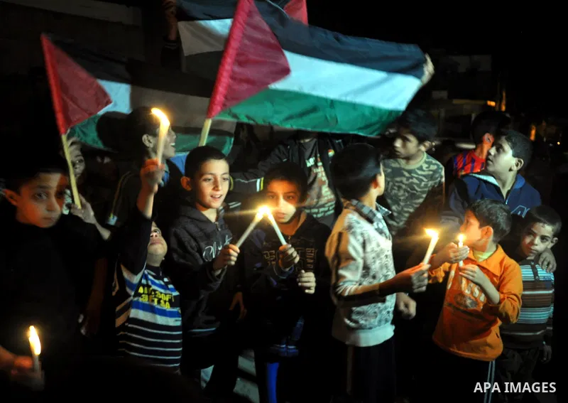 Palestinian children light candles during a rally marking ''Universal Children's Day'' calling for end the blockade on Gaza Strip, in Gaza City on November 20, 2013. Photo by Mohammed Talatene