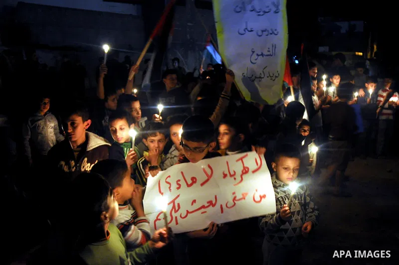 Palestinian children light candles during a rally marking ''Universal Children's Day'' calling for end the blockade on Gaza Strip, in Gaza City on November 20, 2013. Photo by Mohammed Talatene