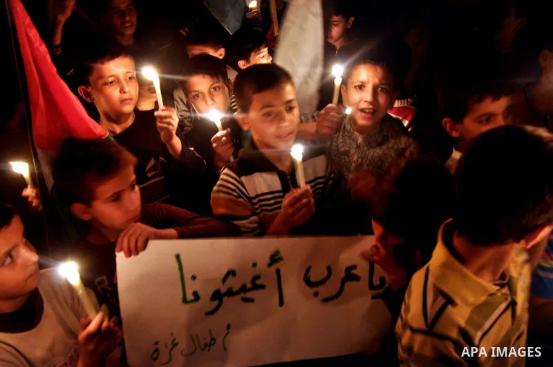 Palestinian children light candles during a rally marking ''Universal Children's Day'' calling for end the blockade on Gaza Strip, in Gaza City on November 20, 2013. Photo by Mohammed Talatene