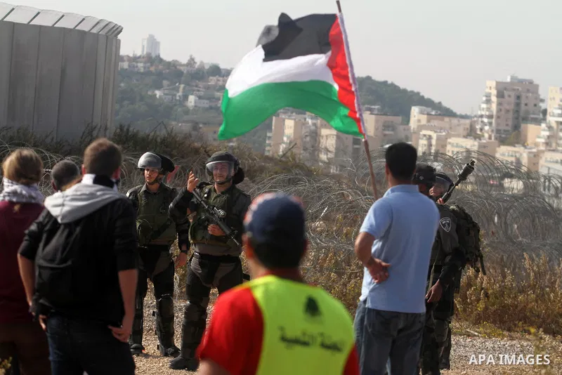 Palestinians argue with Israeli border policemen during the weekly demonstration against Israel's separation barrier in the West Bank village of Bilin, near Ramallah, Friday, Nov. 22, 2013. Photo by Issam Rimawi