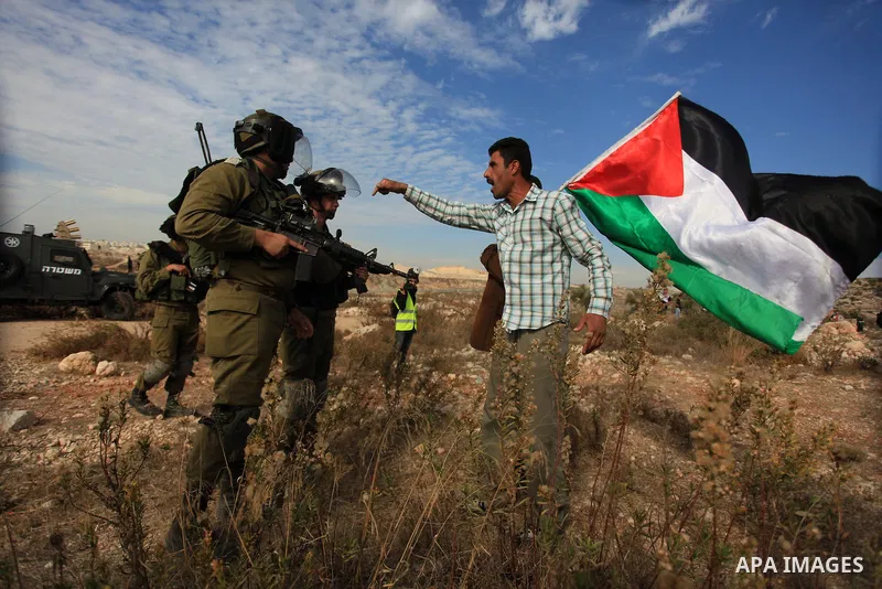 A Palestinian man argues with Israeli border policemen during the weekly demonstration against Israel's separation barrier in the West Bank village of Bilin, near Ramallah, Friday, Nov. 22, 2013. Photo by Issam Rimawi