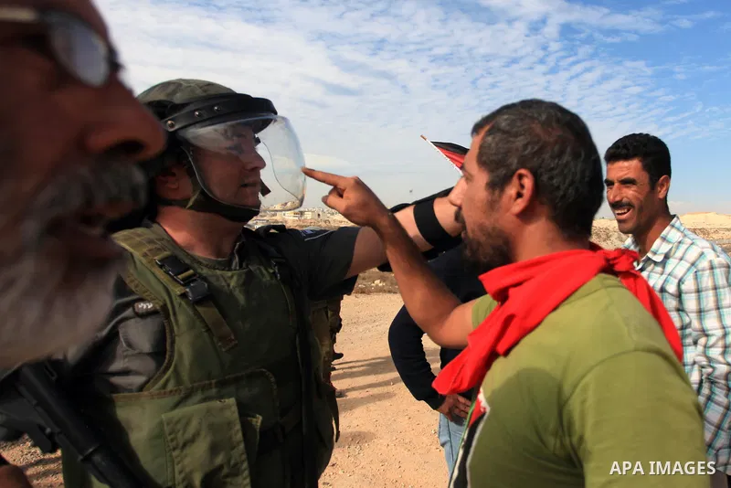 Palestinians argue with Israeli border policemen during the weekly demonstration against Israel's separation barrier in the West Bank village of Bilin, near Ramallah, Friday, Nov. 22, 2013. Photo by Issam Rimawi