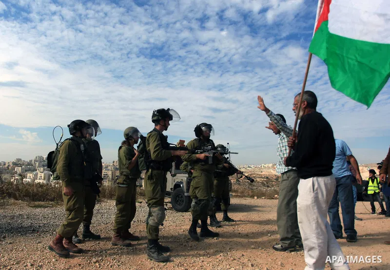 Palestinians argue with Israeli border policemen during the weekly demonstration against Israel's separation barrier in the West Bank village of Bilin, near Ramallah, Friday, Nov. 22, 2013. Photo by Issam Rimawi
