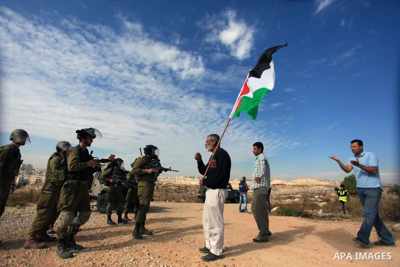 A Palestinian man argues with Israeli border policemen during the weekly demonstration against Israel's separation barrier in the West Bank village of Bilin, near Ramallah, Friday, Nov. 22, 2013. Photo by Issam Rimawi