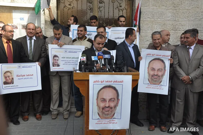 Palestinian journalists carry placards during a protest in solidarity with Palestinian journalists in the West Bank, in front of Red cross in Gaza city, on Nov. 27, 2013. Photo by Mohammed Talatene