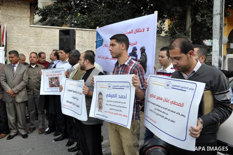 Palestinian journalists carry placards during a protest in solidarity with Palestinian journalists in the West Bank, in front of Red cross in Gaza city, on Nov. 27, 2013. Photo by Mohammed Talatene