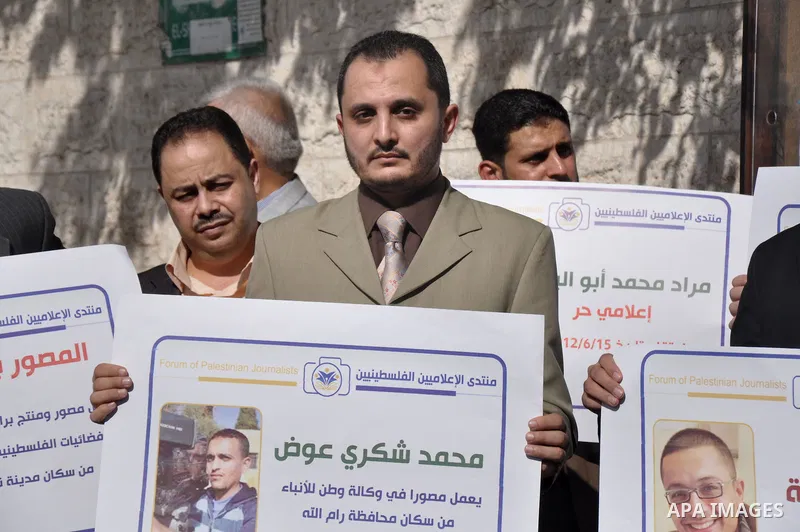 Palestinian journalists carry placards during a protest in solidarity with Palestinian journalists in the West Bank, in front of Red cross in Gaza city, on Nov. 27, 2013. Photo by Mohammed Talatene