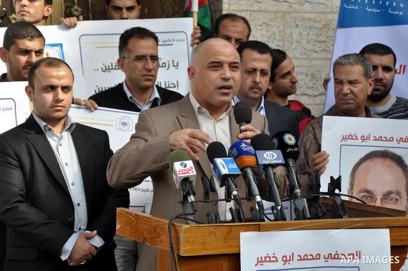 Palestinian journalists carry placards during a protest in solidarity with Palestinian journalists in the West Bank, in front of Red cross in Gaza city, on Nov. 27, 2013. Photo by Mohammed Talatene