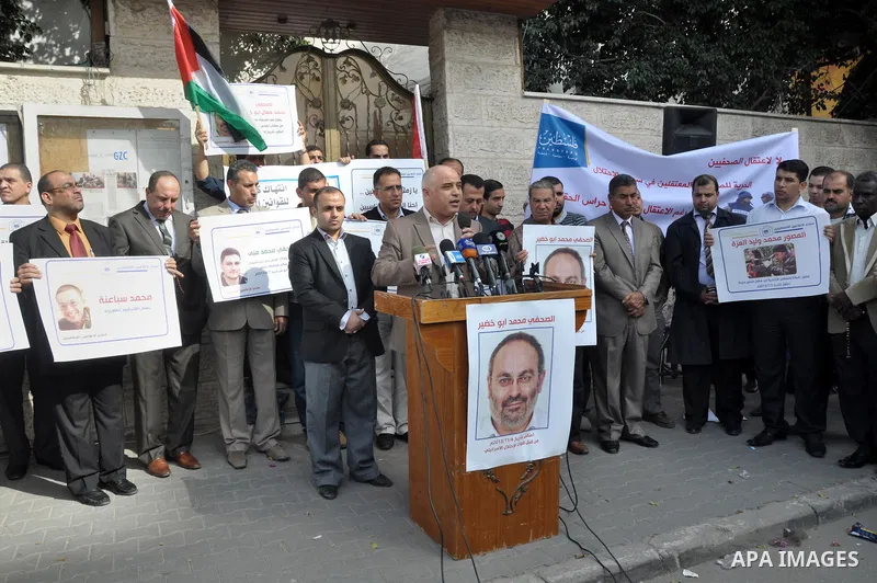 Palestinian journalists carry placards during a protest in solidarity with Palestinian journalists in the West Bank, in front of Red cross in Gaza city, on Nov. 27, 2013. Photo by Mohammed Talatene