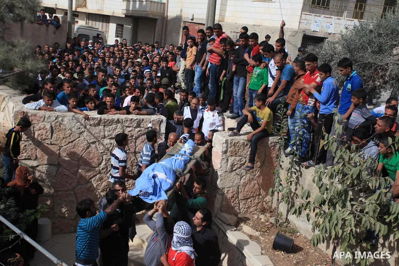 Mourners carry the bodies of Palestinian militants Mahmoud al-Najjar, and Moses Makhamreh, during their funeral on November 27, 2013 in the West Bank village of Yatta, one day after he was shot dead, along with two other...
