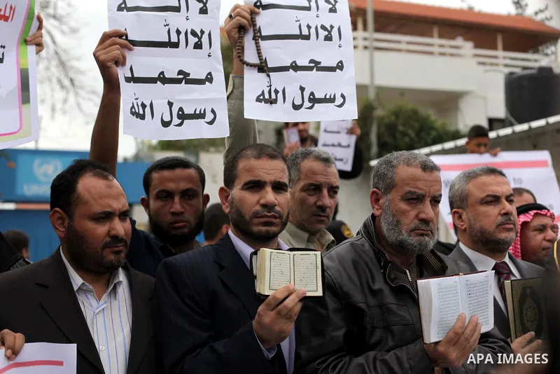 Palestinian protesters hold placards during a protest against Angola's government, in Gaza City on November 27, 2013. Angola's government on November 26, 2013 denied it had banned Islam and closed mosques in the country,...