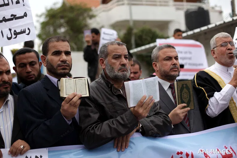 Palestinian protesters hold placards during a protest against Angola's government, in Gaza City on November 27, 2013. Angola's government on November 26, 2013 denied it had banned Islam and closed mosques in the country,...