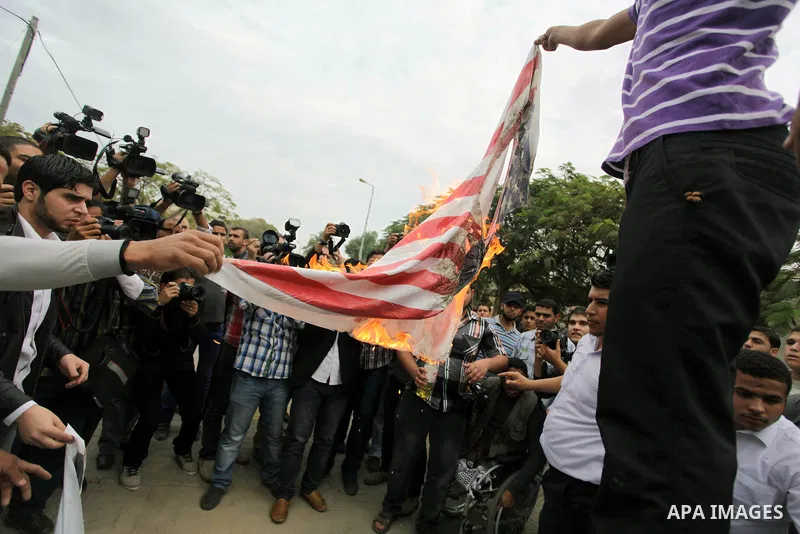 Palestinian protester burn a U.s flag during a protest against Angola's government, in Gaza City on November 27, 2013. Angola's government on November 26, 2013 denied it had banned Islam and closed mosques in the country...