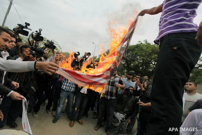 Palestinian protester burn a U.s flag during a protest against Angola's government, in Gaza City on November 27, 2013. Angola's government on November 26, 2013 denied it had banned Islam and closed mosques in the country...