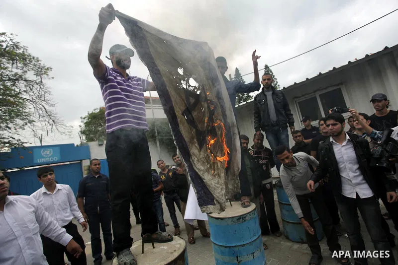Palestinian protester burn an Israeli flag during a protest against Angola's government, in Gaza City on November 27, 2013. Angola's government on November 26, 2013 denied it had banned Islam and closed mosques in the co...
