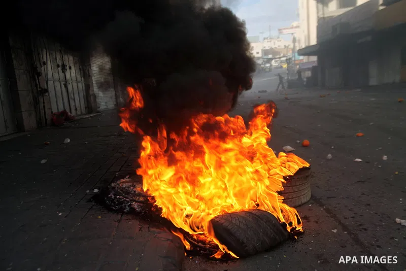 Palestinian protesters throw stones at Israeli soldiers during clashes in the West bank city of Hebron, 27 November 2013. The clashes began after the killing of three Palestinians militants in the West bank village of Ya...