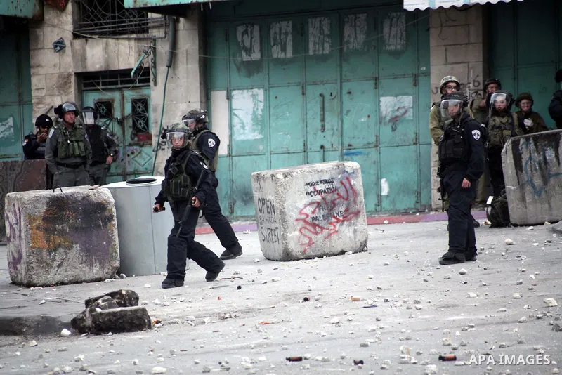 Israeli soldiers take position during clashes with Palestinian protesters in the West bank city of Hebron, 27 November 2013. The clashes began after the killing of three Palestinians militants in the West bank village of...