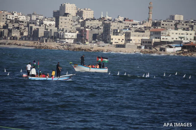 Model boats, with chidren's and countries' names on sails, are launched by Palestinian children during a rally to protest against the Israeli siege of the Gaza Strip on November 30, 2013 at Gaza City harbour. Photo by As...