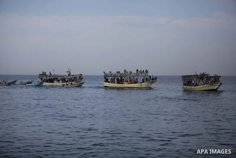 Palestinians sail their boats as part of a convoy that was launched at the initiative of the "Intifada Youth Coalition" (IYC) to break the naval blockade of Gaza as a protest against the Israeli siege on December 2, 2013...