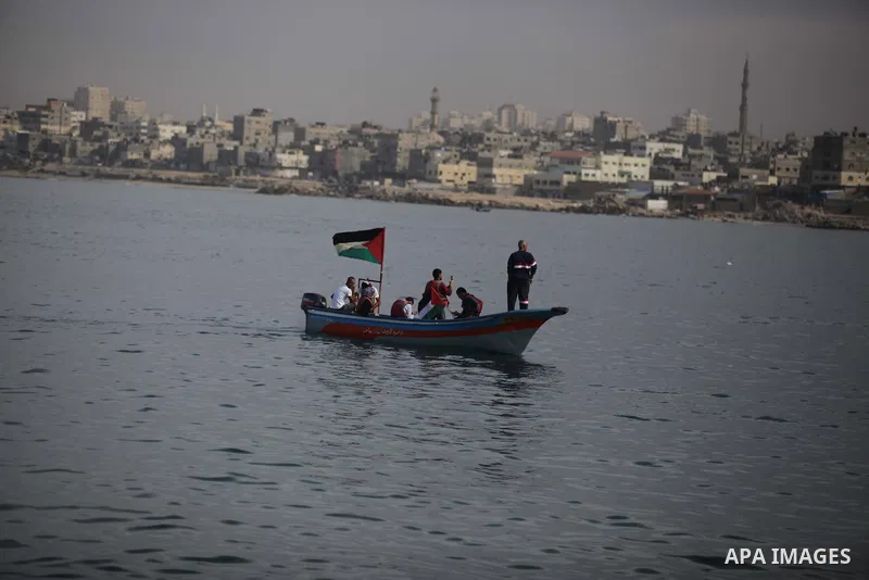 Palestinians sail their boats as part of a convoy that was launched at the initiative of the "Intifada Youth Coalition" (IYC) to break the naval blockade of Gaza as a protest against the Israeli siege on December 2, 2013...