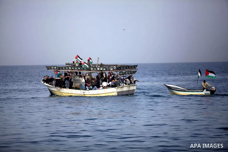 Palestinians sail their boats as part of a convoy that was launched at the initiative of the "Intifada Youth Coalition" (IYC) to break the naval blockade of Gaza as a protest against the Israeli siege on December 2, 2013...