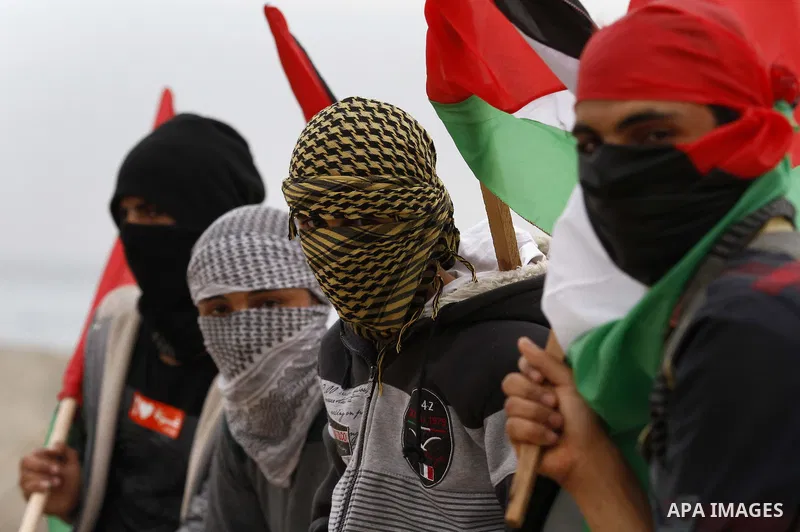 Palestinians look at boats leaving as a convoy is launched at the initiative of the "Intifada Youth Coalition" (IYC) to break the naval blockade of Gaza as a protest against the Israeli siege on December 2, 2013 at the p...