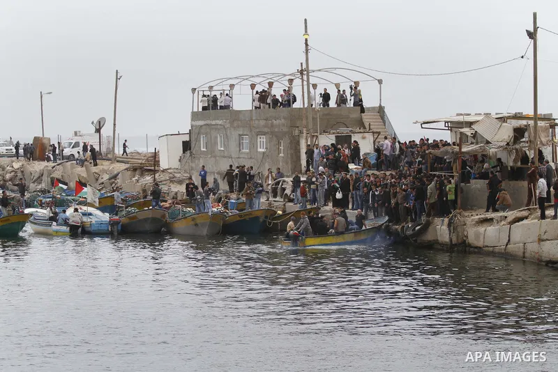 Palestinians sail their boats as part of a convoy that was launched at the initiative of the "Intifada Youth Coalition" (IYC) to break the naval blockade of Gaza as a protest against the Israeli siege on December 2, 2013...
