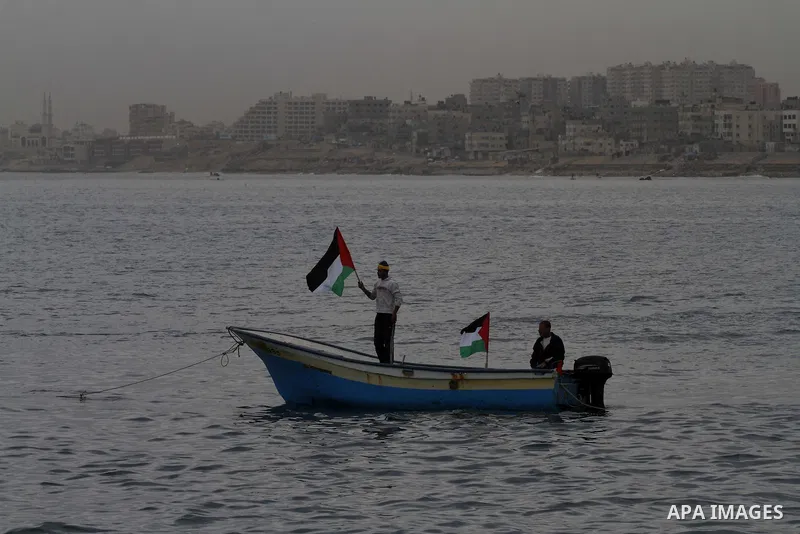 Palestinians sail their boats as part of a convoy that was launched at the initiative of the "Intifada Youth Coalition" (IYC) to break the naval blockade of Gaza as a protest against the Israeli siege on December 2, 2013...