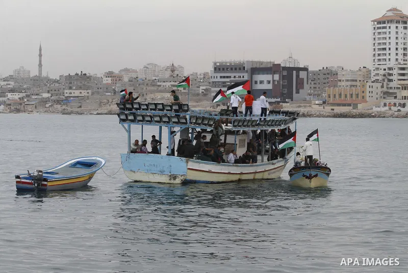 Palestinians sail their boats as part of a convoy that was launched at the initiative of the "Intifada Youth Coalition" (IYC) to break the naval blockade of Gaza as a protest against the Israeli siege on December 2, 2013...