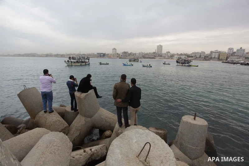 Palestinians sail their boats as part of a convoy that was launched at the initiative of the "Intifada Youth Coalition" (IYC) to break the naval blockade of Gaza as a protest against the Israeli siege on December 2, 2013...