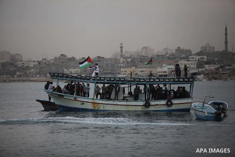Palestinians sail their boats as part of a convoy that was launched at the initiative of the "Intifada Youth Coalition" (IYC) to break the naval blockade of Gaza as a protest against the Israeli siege on December 2, 2013...