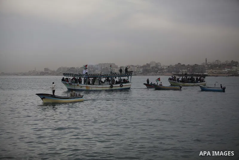 Palestinians sail their boats as part of a convoy that was launched at the initiative of the "Intifada Youth Coalition" (IYC) to break the naval blockade of Gaza as a protest against the Israeli siege on December 2, 2013...