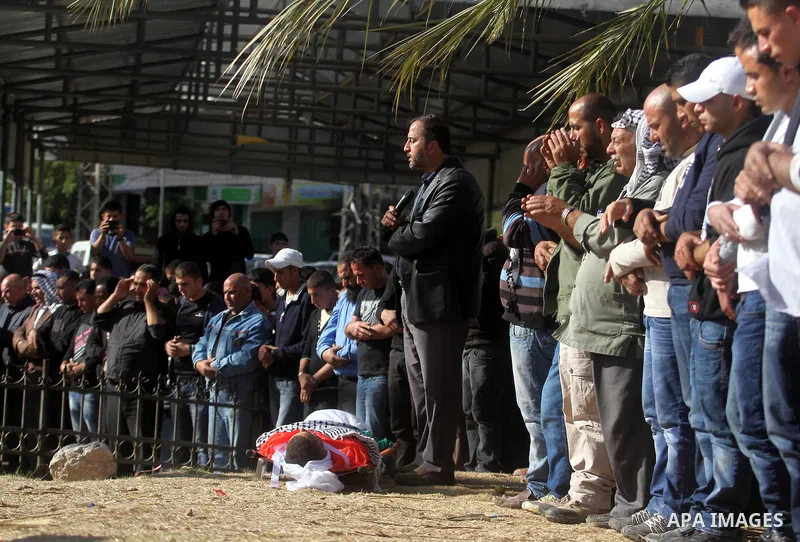 Palestinians pray over the body of Palestinian worker Antar al-Aqraa, during his funeral at Qabalan village near the Wet Bank City of Nablus, 02 December 2013. A volunteer for the Israeli border police allegedly shot and...