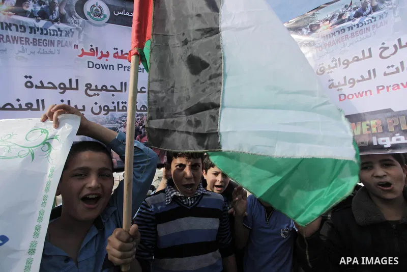 Palestinian protesters hold placards and flags during a protest against the Israeli "Prawer plan" in Gaza City on Dec. 02, 2013. "Prawer plan" is a comprehensive plan approved by Israeli government, one of whose aims is...