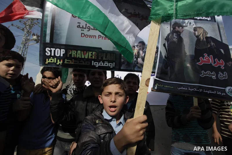 Palestinian protesters hold placards and flags during a protest against the Israeli "Prawer plan" in Gaza City on Dec. 02, 2013. "Prawer plan" is a comprehensive plan approved by Israeli government, one of whose aims is...