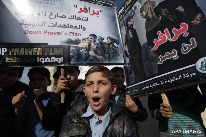Palestinian protesters hold placards and flags during a protest against the Israeli "Prawer plan" in Gaza City on Dec. 02, 2013. "Prawer plan" is a comprehensive plan approved by Israeli government, one of whose aims is...