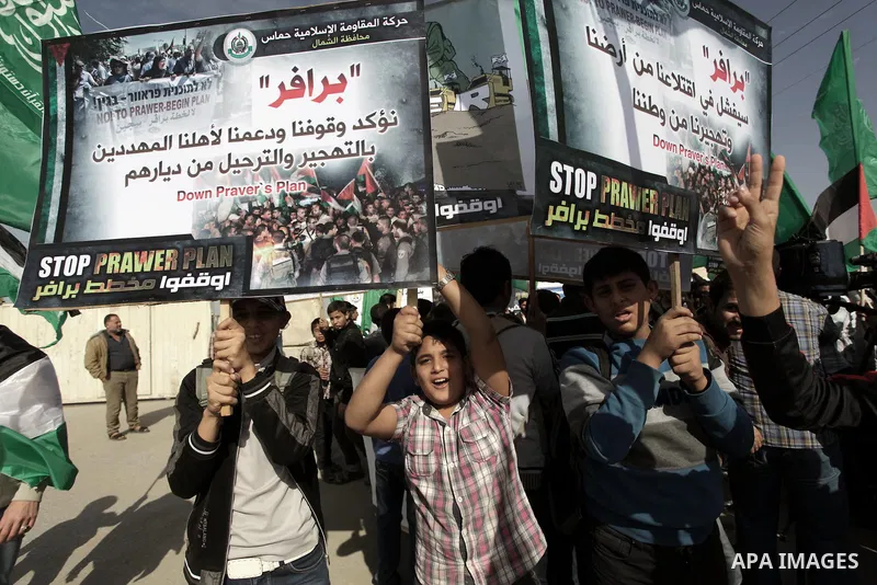 Palestinian protesters hold placards and flags during a protest against the Israeli "Prawer plan" in Gaza City on Dec. 02, 2013. "Prawer plan" is a comprehensive plan approved by Israeli government, one of whose aims is...