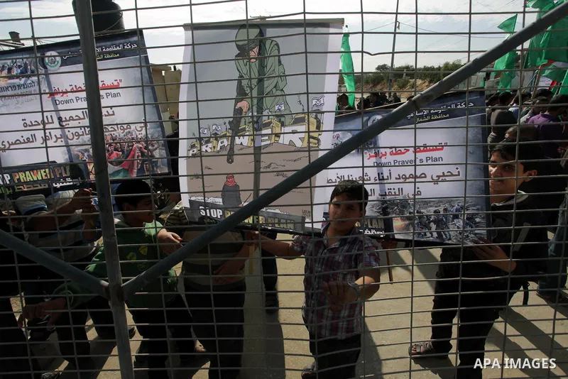 Palestinian protesters hold placards and flags during a protest against the Israeli "Prawer plan" in Gaza City on Dec. 02, 2013. "Prawer plan" is a comprehensive plan approved by Israeli government, one of whose aims is...